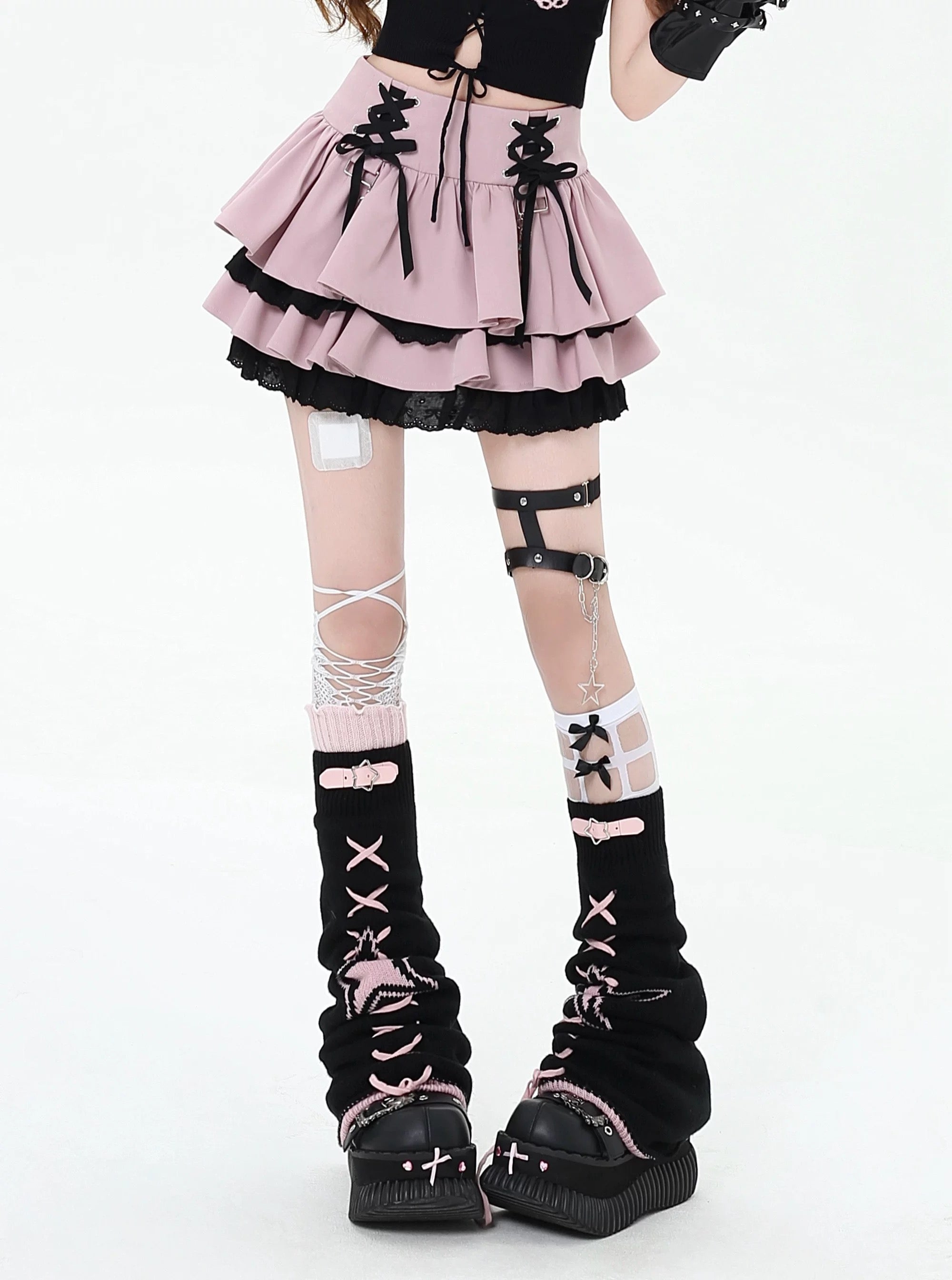 Model wearing black gothic ruffle mini skirt with red bow accents